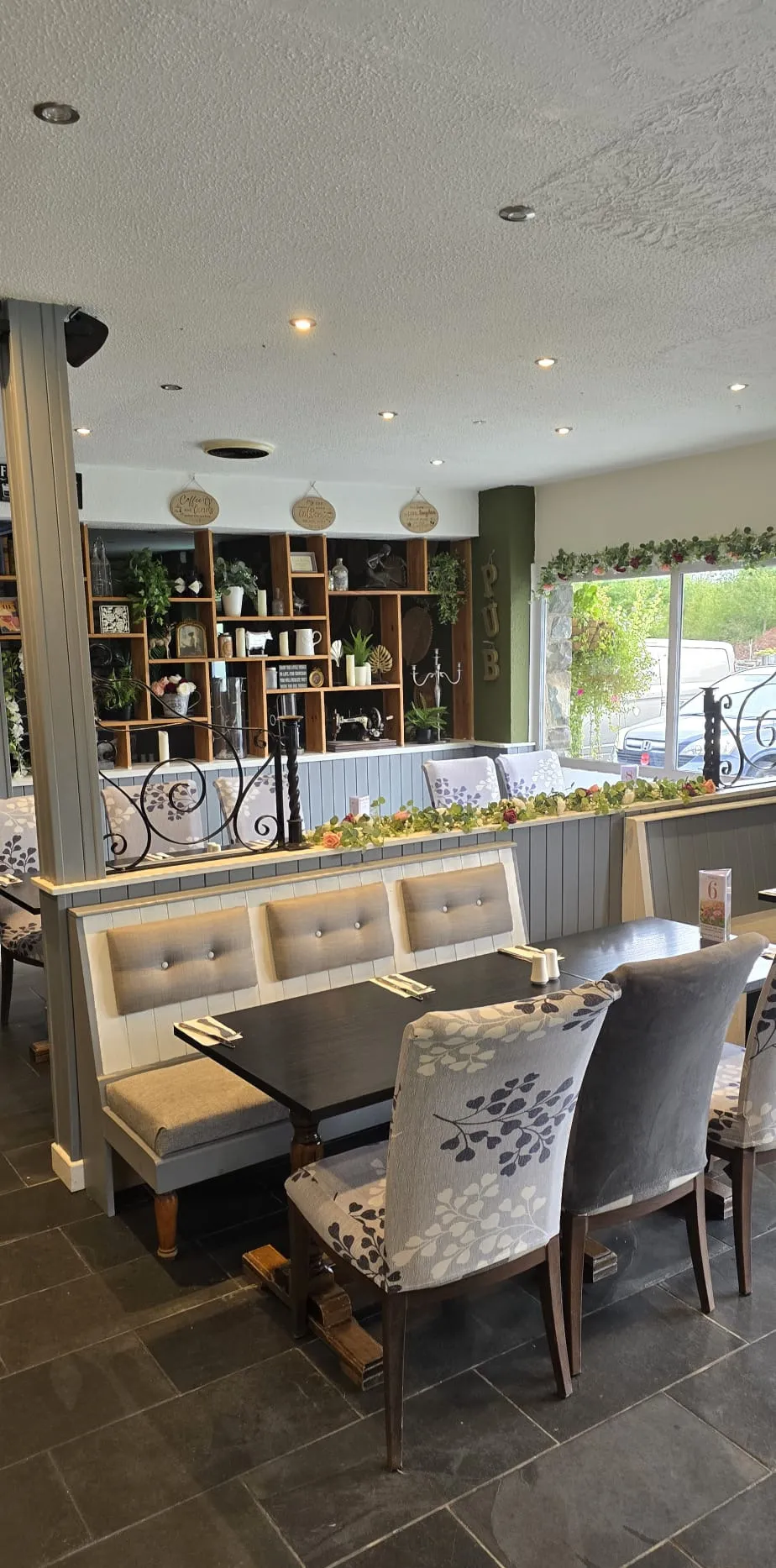 A restaurant table set beside the window, with a view out to the garden
