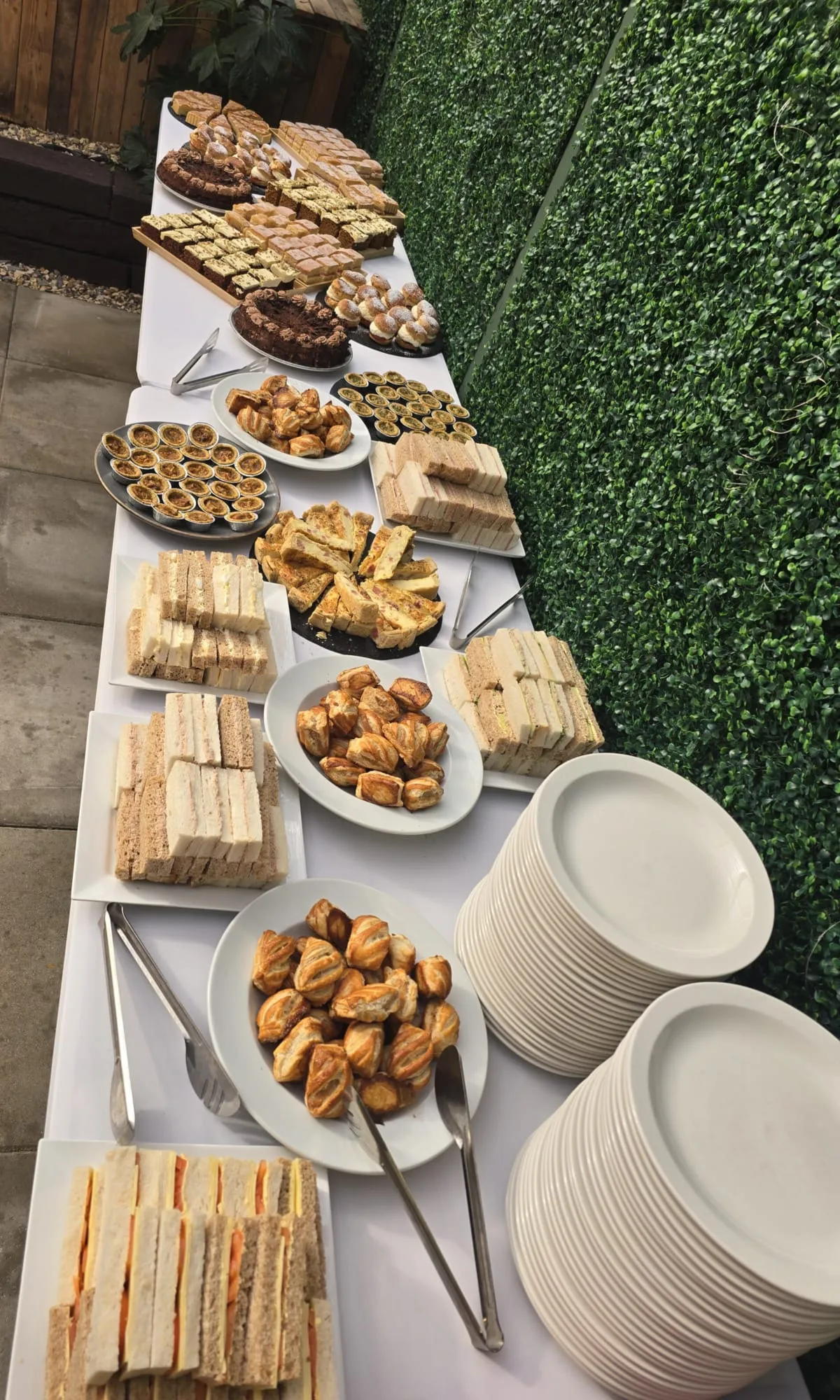 Buffet platters of sandwiches, savouries and quiche laid out on white plates