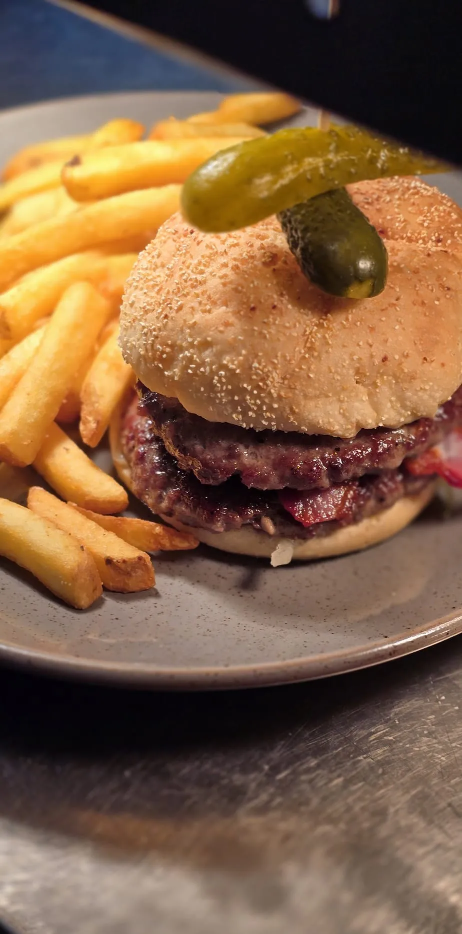 A burger in a seeded bun with chips, served at the Bryn Arms