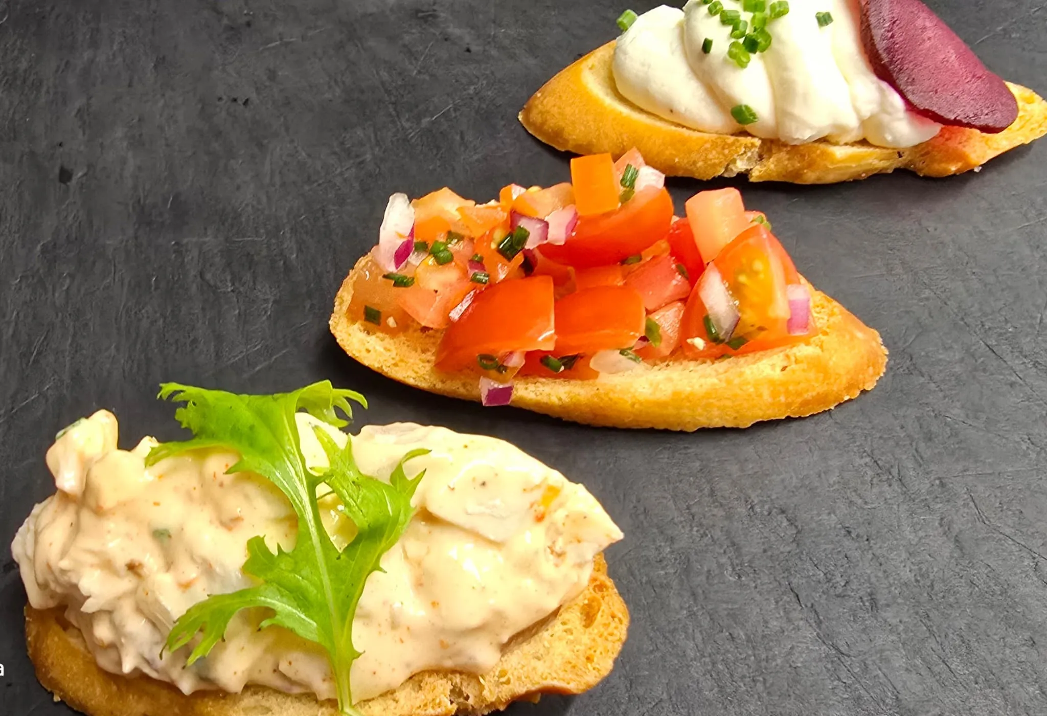 Three crostini canapes on slate