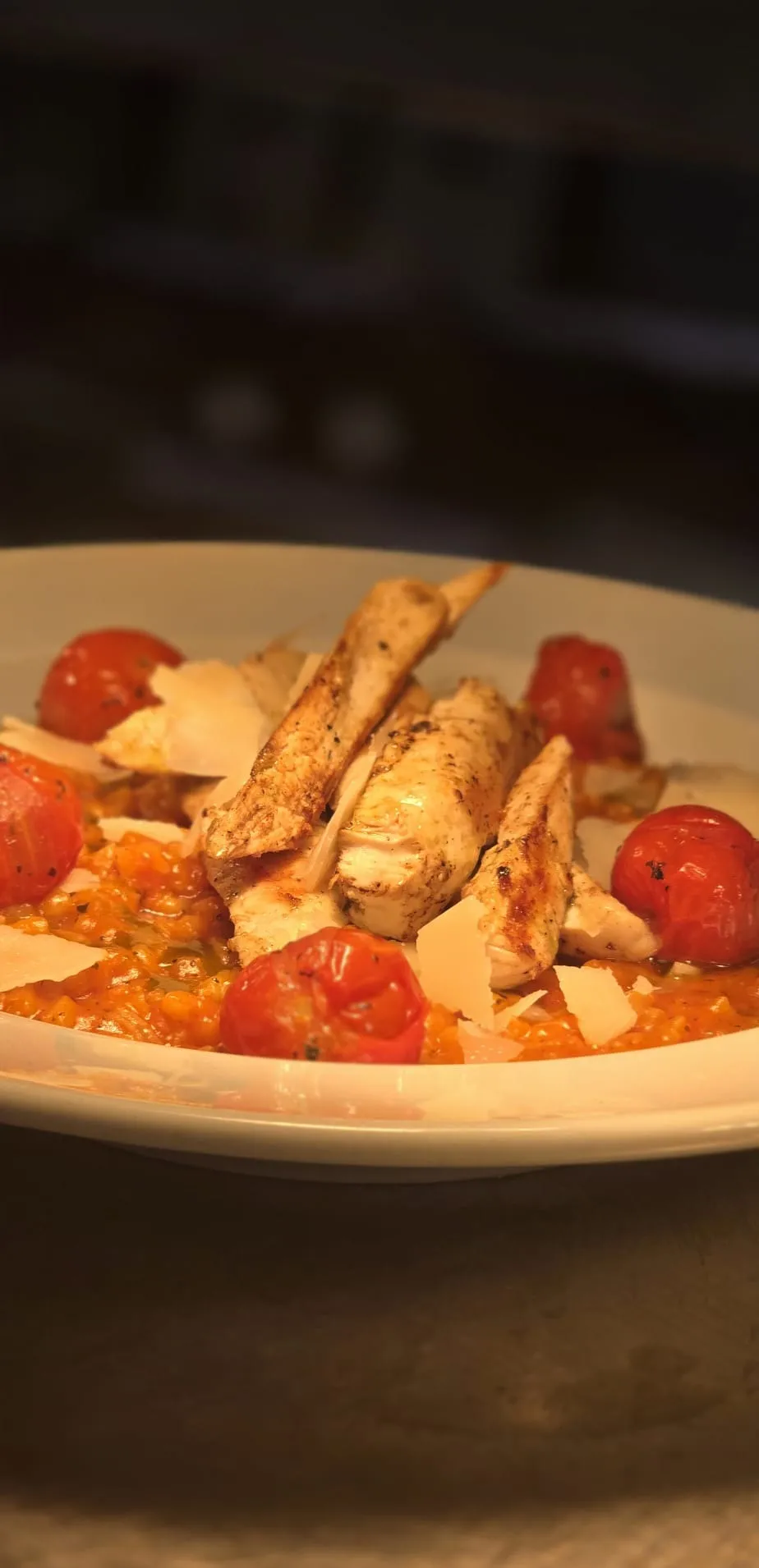 Tomato risotto topped with griddled chicken and parmesan
