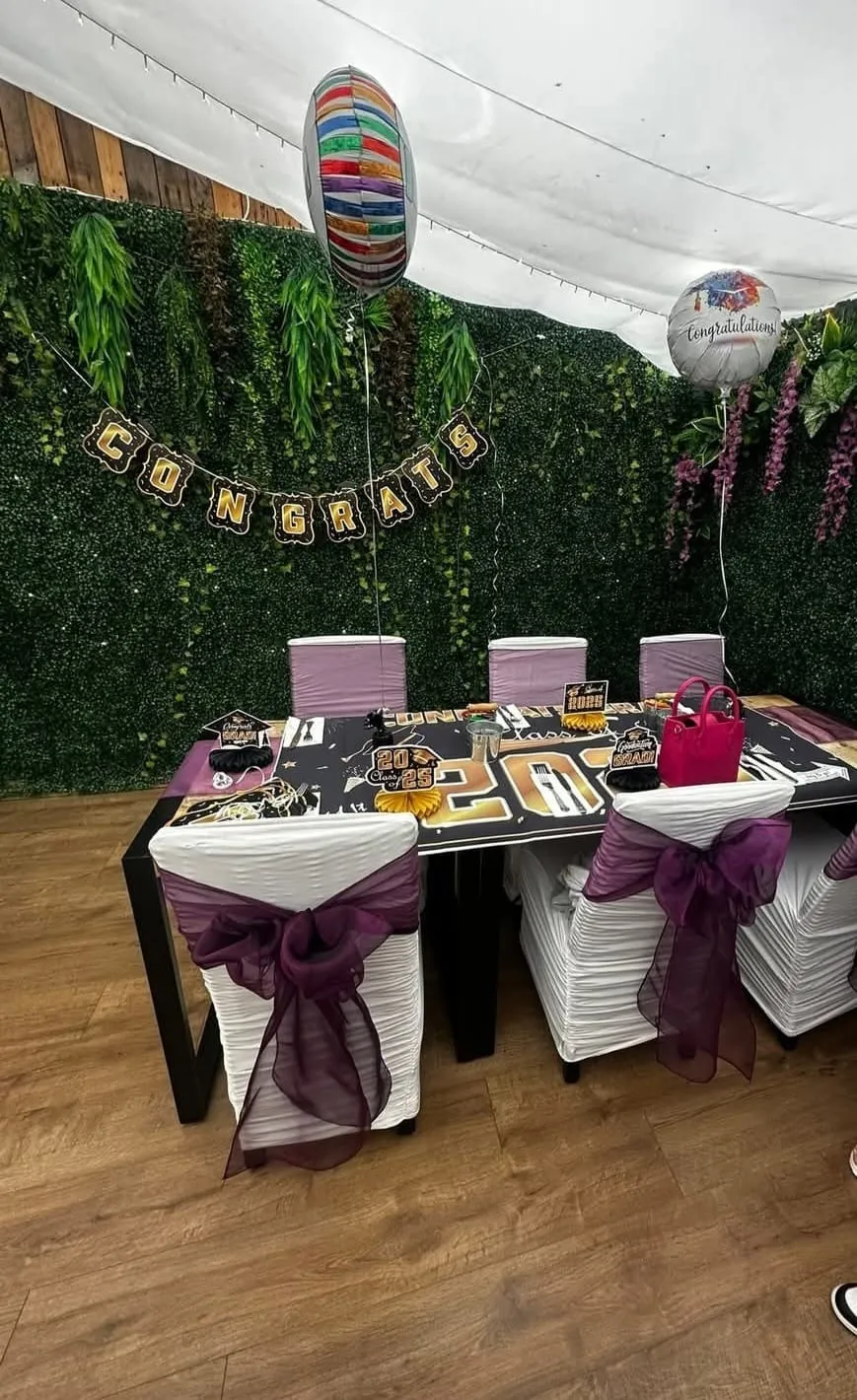 A graduation party table with a Congrats banner, balloons and a Class of 2025 runner