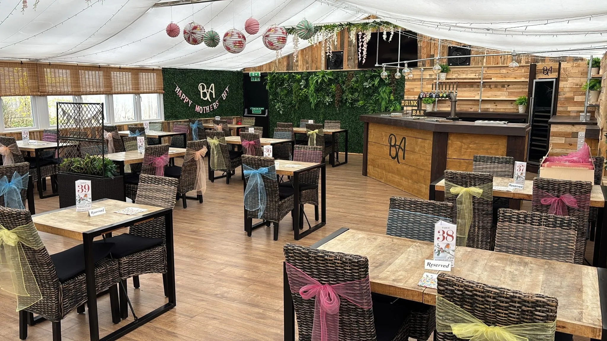 The conservatory with a Happy Mothers Day banner, pastel sashes and the living wall