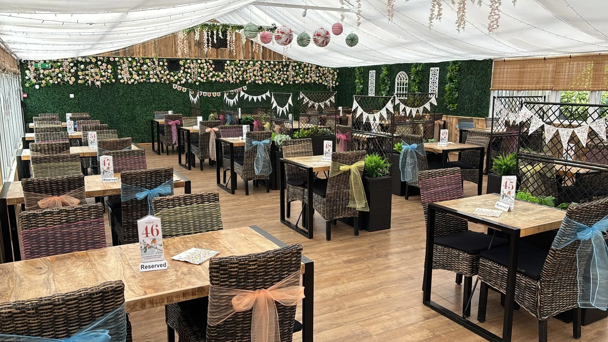 The conservatory laid for a special occasion service with numbered tables and bunting