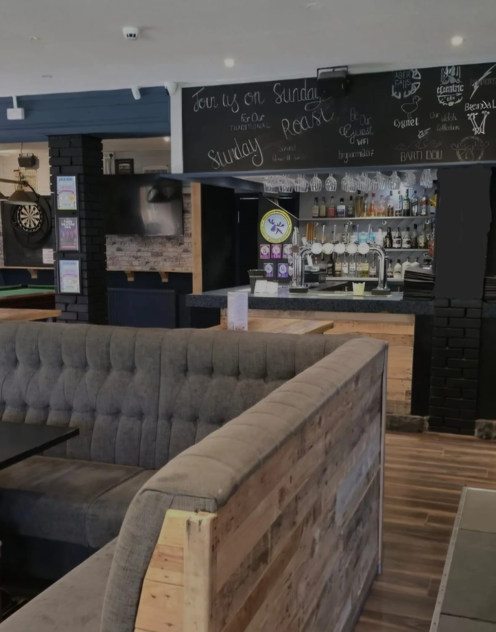 Booth seating and reclaimed wood panelling in front of the main bar