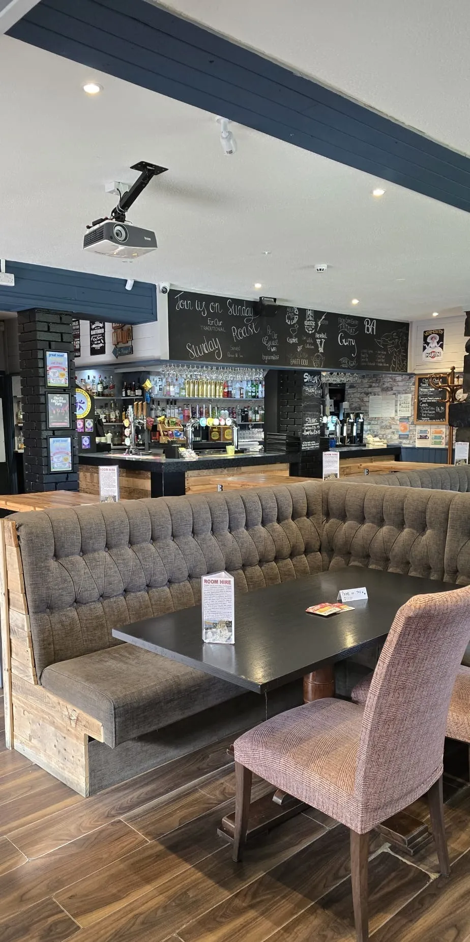 A dining booth and table in front of the main bar