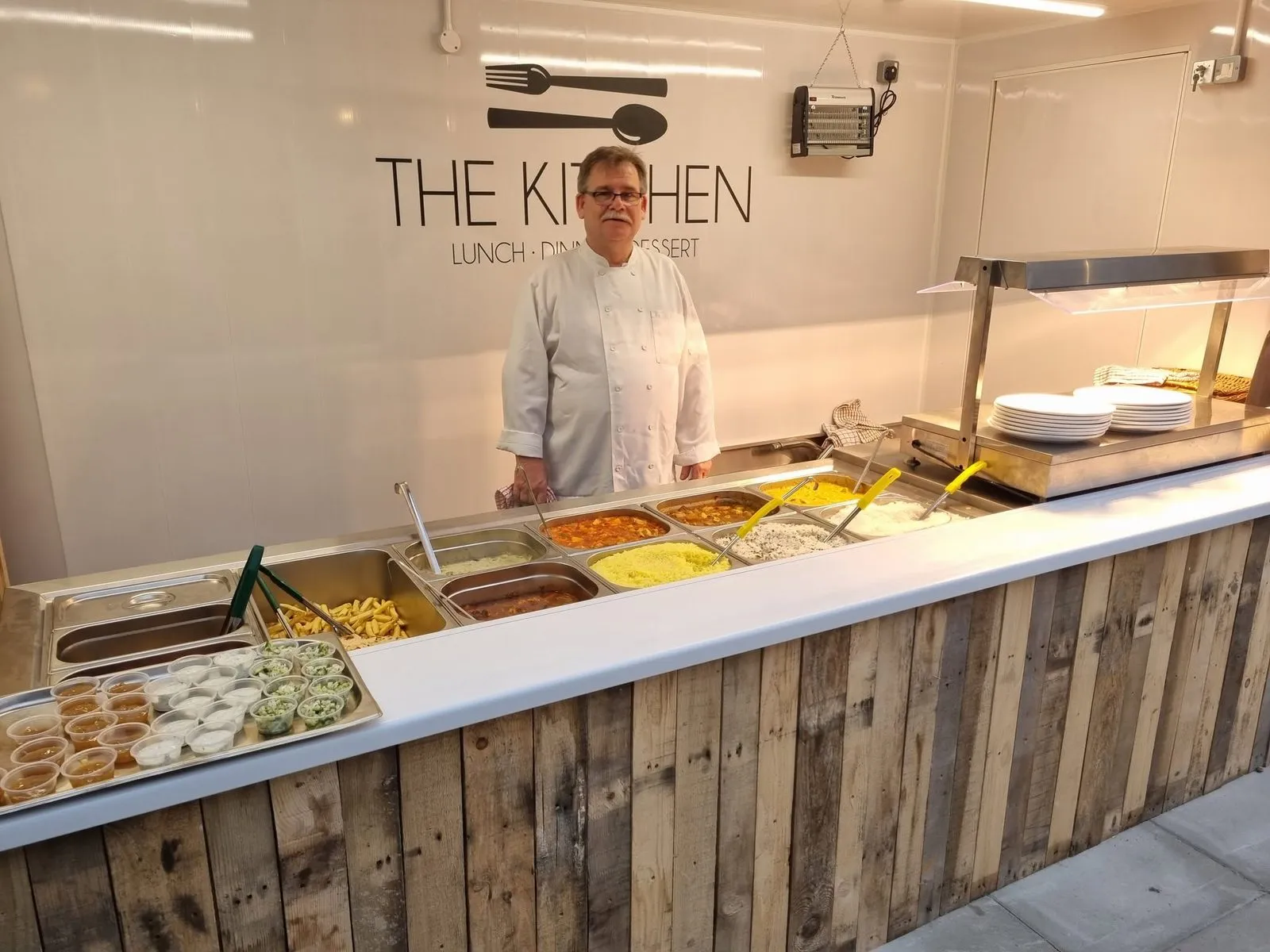 The Kitchen servery, with a chef behind a counter of house made dishes