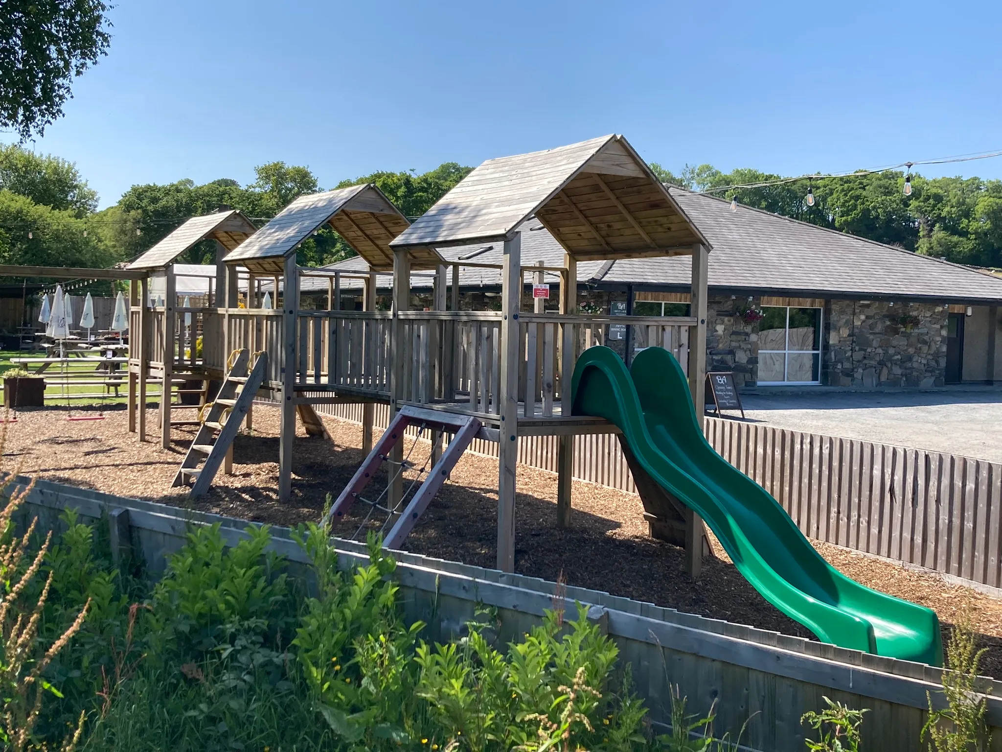 The children's play area beside the pub: a three tower climbing frame with a green slide