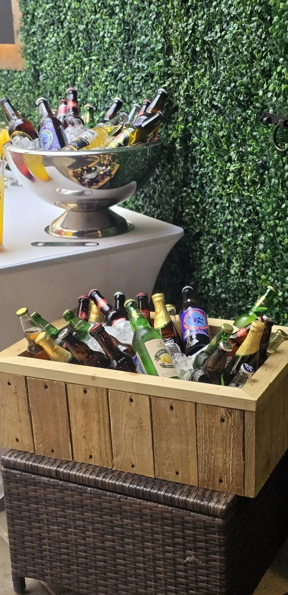 Bottles on ice beside the flower wall