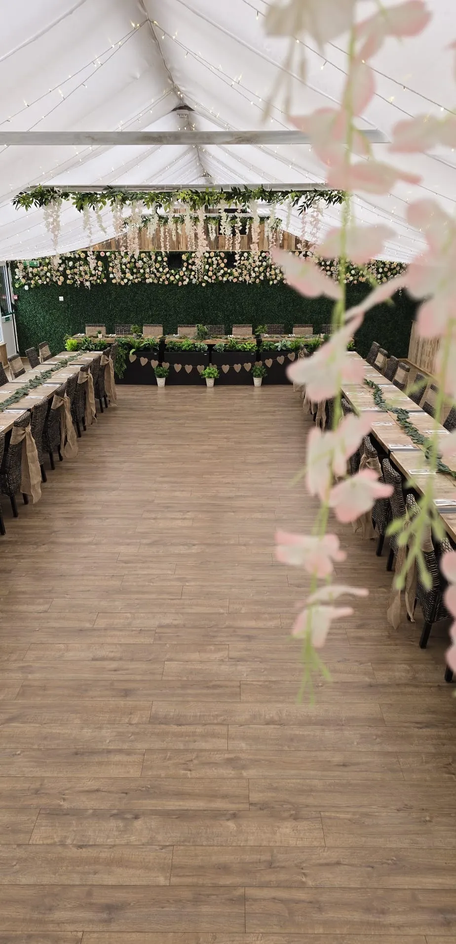 Long banquet tables with burlap heart bunting and planters