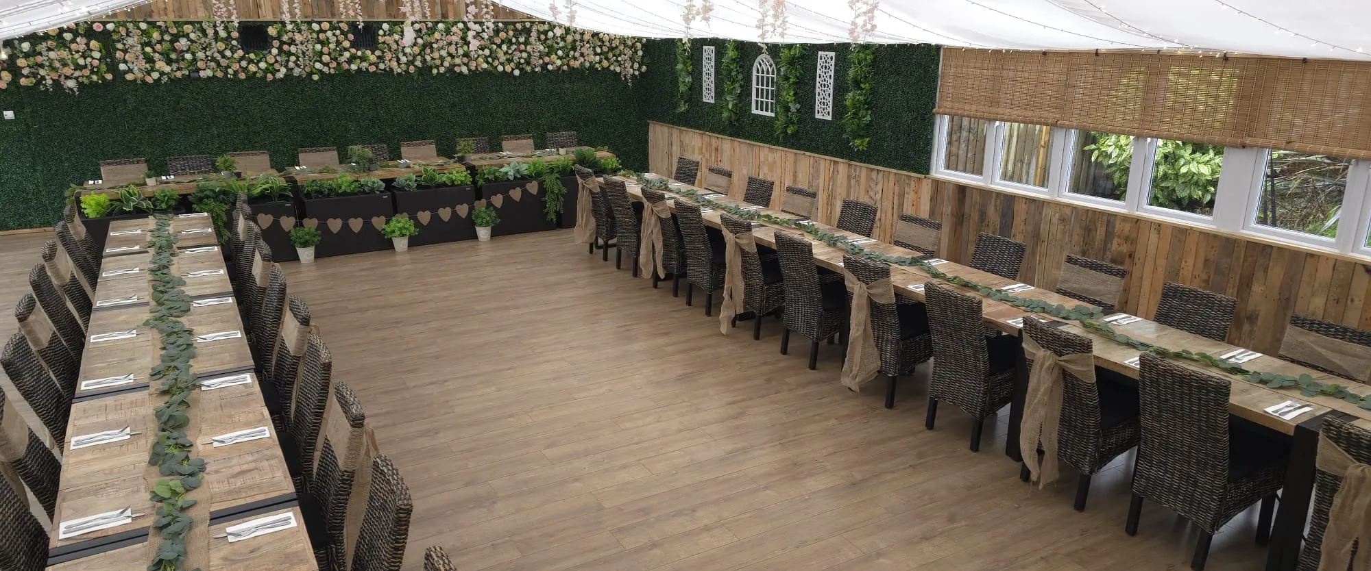 U shaped banquet seating with wicker chairs and eucalyptus runners